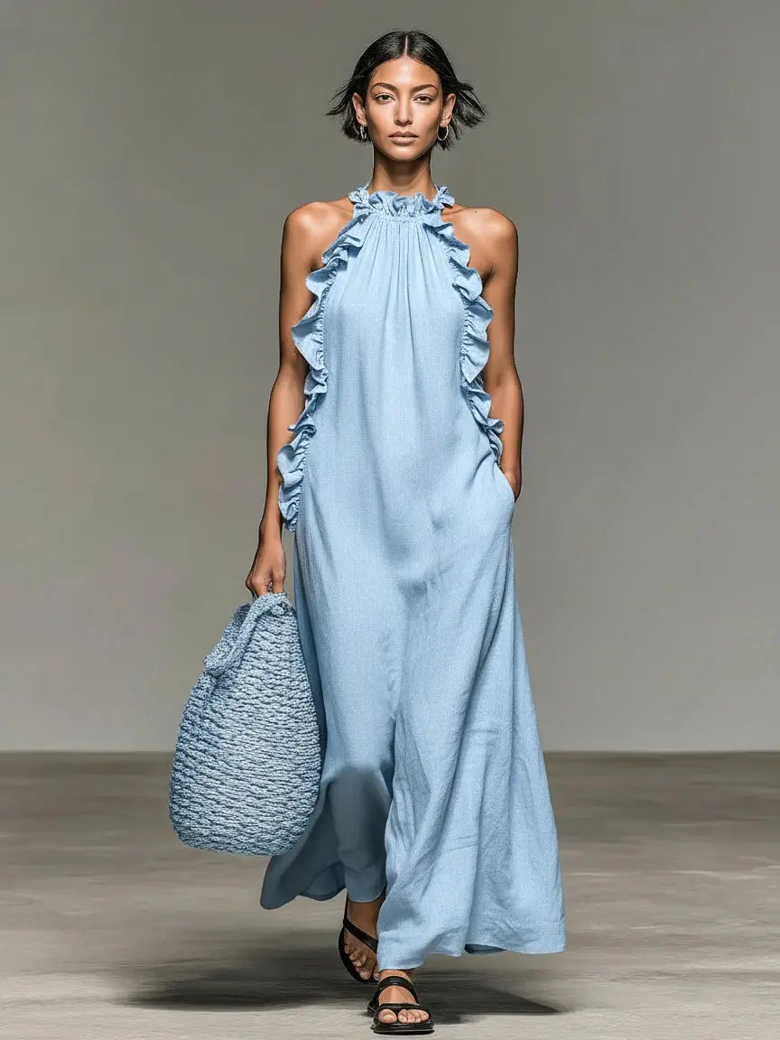 Une robe de villégiature longue maxi sans manches bleu clair, à encolure licou à volants et tissu fluide, présentant le côté arrière de la robe longue maxi à encolure licou à volants et dos nu.