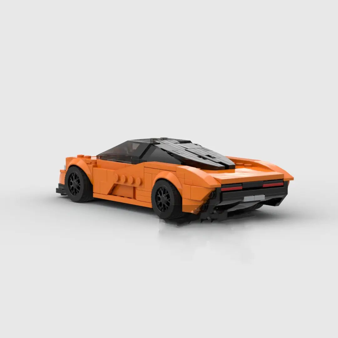 Juguete de coche deportivo de bloques de construcción Orange McLaren Speedtail con ruedas negras y techo transparente, mostrado desde el lado delantero.