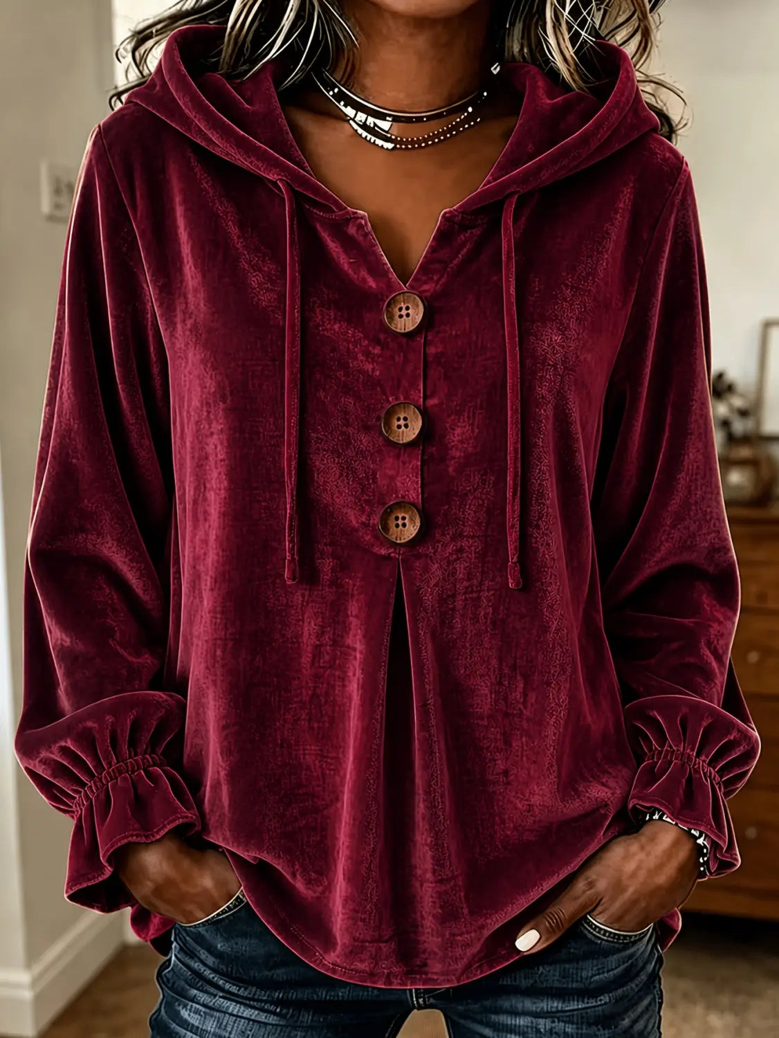 Sudadera de terciopelo burdeos intenso con botones de madera y puños fruncidos.