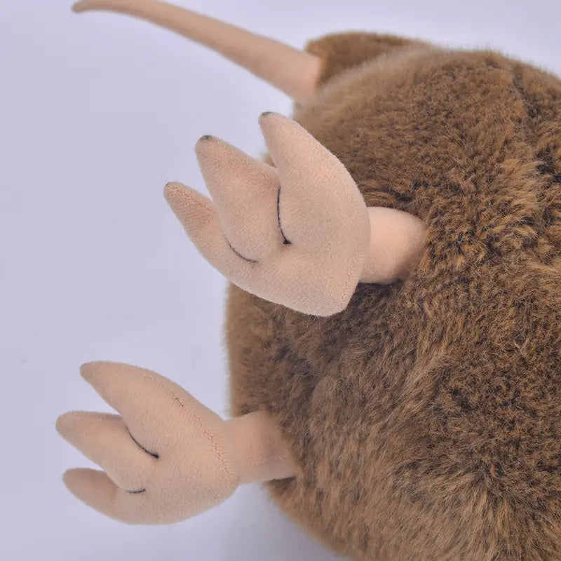 茶色のふわふわした毛並み、淡いベージュの手足、閉じた目を備えた、キウイバードのぬいぐるみキーチェーン。