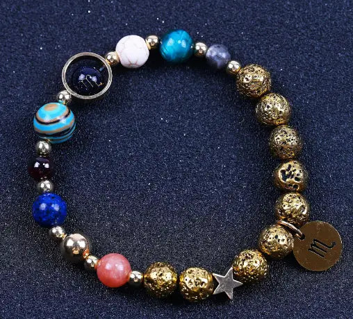 Zodiac volcanic stone beaded bracelet featuring gold-toned lava stone beads turquoise and blue glass orbs with a silver star charm and a bronze zodiac sign pendant.