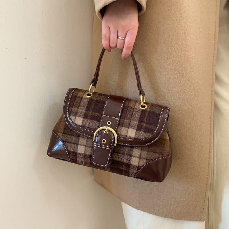Bolso bandolera de cuadros marrones con ribete de cuero y hebilla en tono dorado para un estilo vintage.