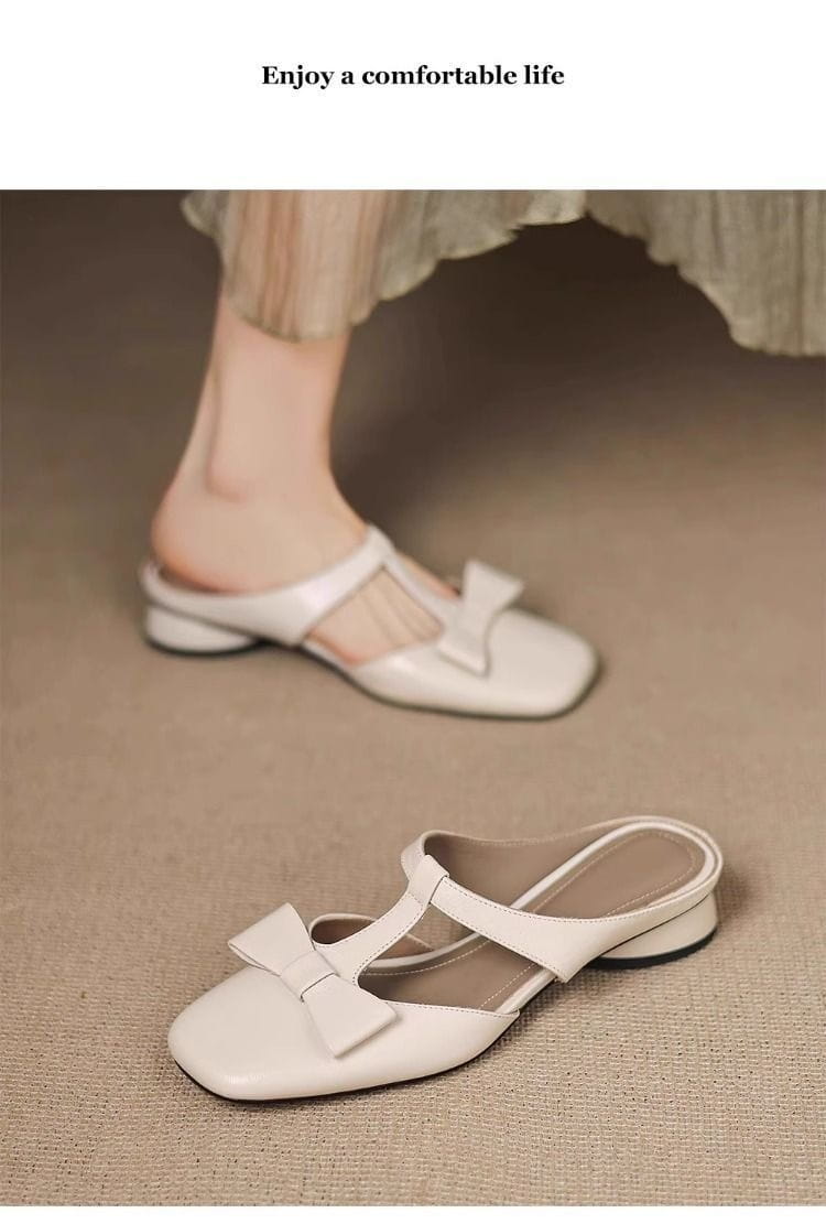 White leather mule flats for women featuring a square toe and a decorative bow on the front.