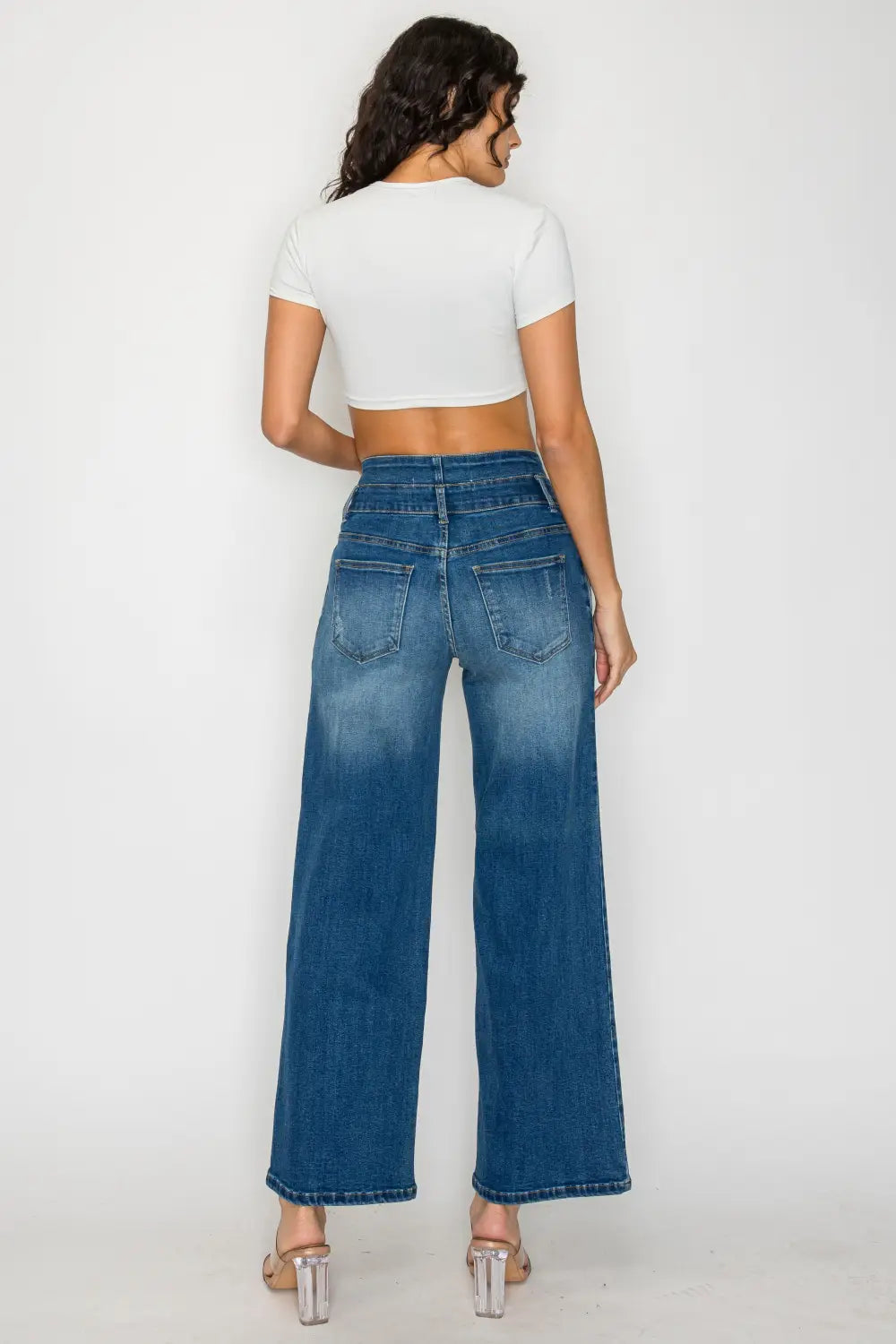Medium blue wide leg denim jeans featuring high-waisted design and wide-leg cut made from blue denim fabric.