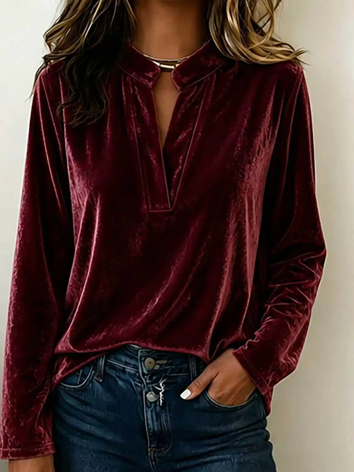 Eine reiches Burgunder-Samtbluse mit V-Ausschnitt und langen Ärmeln für Damen mit einer weichen, plüschigen Textur und dezentem Schimmer.