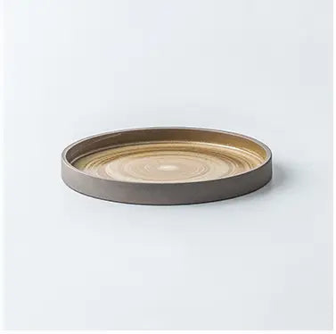 Circular ceramic tray with concentric rings of warm gold and muted gray from a retro Japanese dinnerware ceramic tableware set.