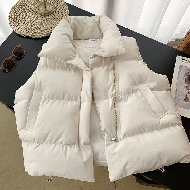 Cream-colored women quilted puffer vest with a loose fit, sleeveless design, quilted pattern, and front zipper closure.