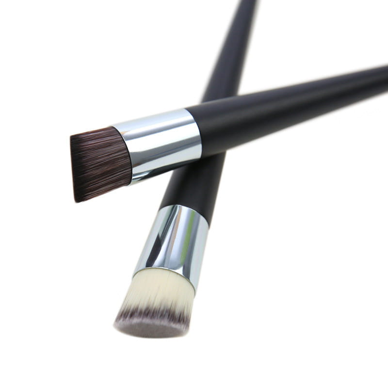 Two black-handled foundation brushes with silver ferrules featuring an angled dark brown bristle and a round off-white bristle for precise makeup application.