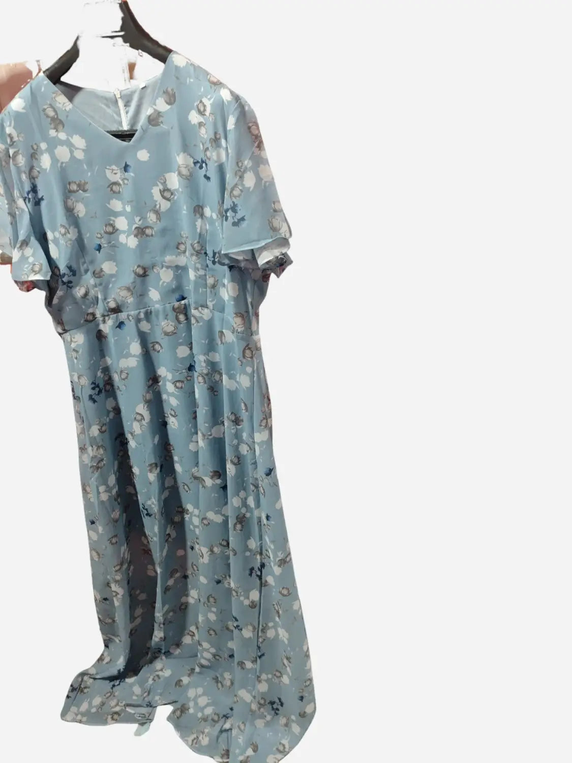 Une robe longue d’été à décolleté en V floral volanté bleu clair, réalisée dans un tissu léger et transparent, avec des manches courtes volantées.