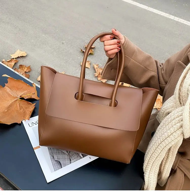 Brown leather vintage structured tote bag with top handles and a sleek design.