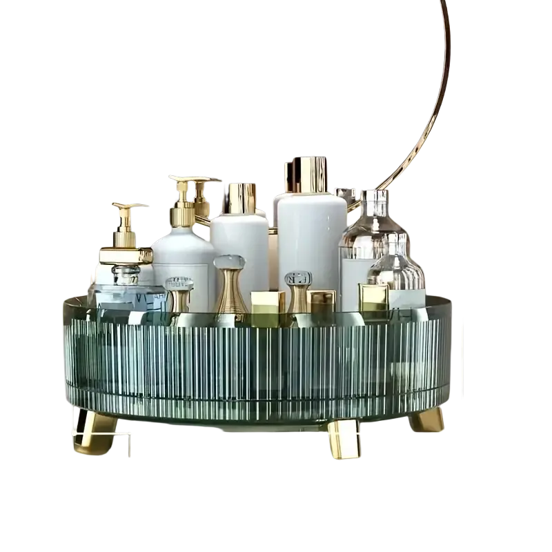 A teal green glass 360 rotating makeup organizer with vertical ridges and gold legs holding white and clear bottles