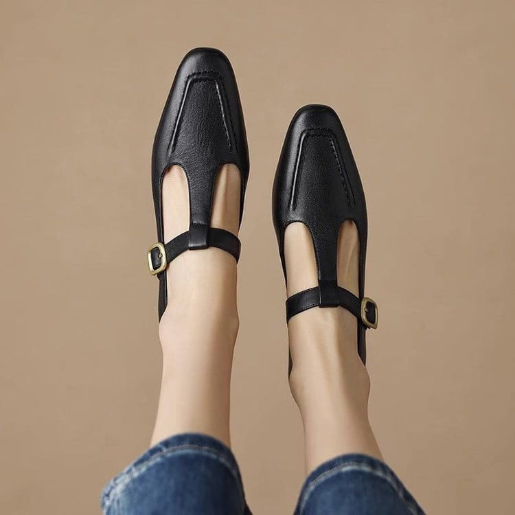 Zapatos planos de cuero negro con correa en T, detalles de hebilla en tono dorado, con diseño de puntera cuadrada y estilo Mary Jane.