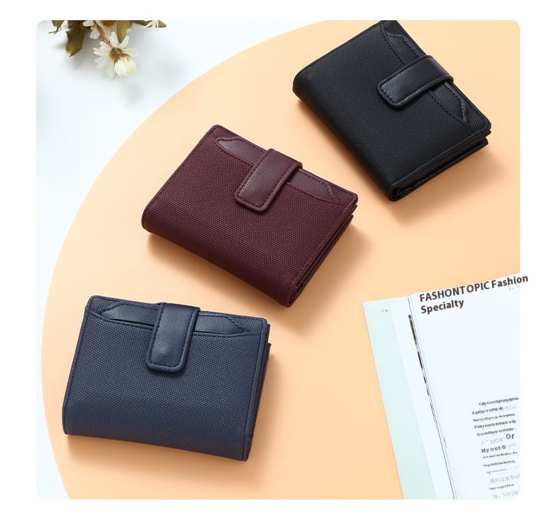 Three compact leather wallet women’s short woven textured purses in black burgundy and navy blue with matching leather straps.