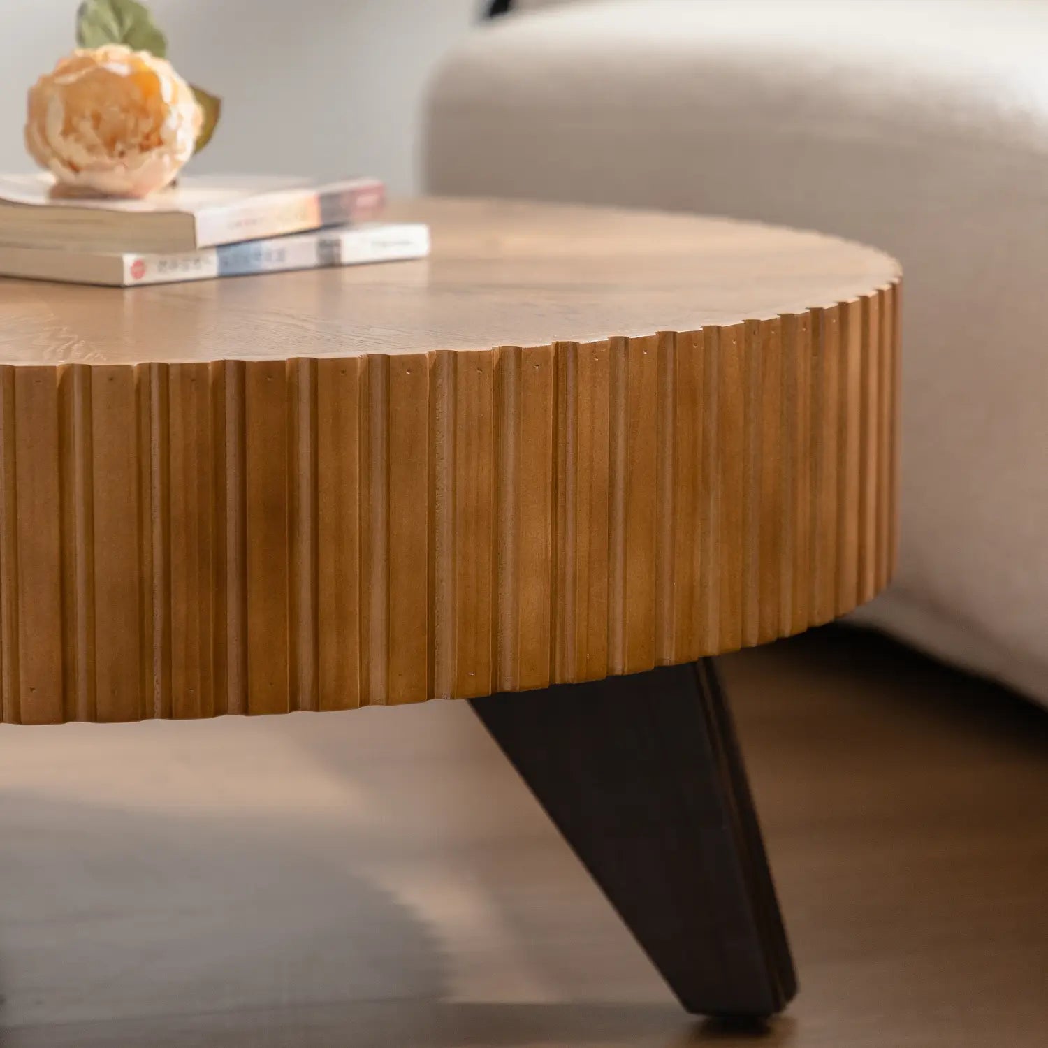 35.4 round retro coffee table with warm-toned wooden fluted edge top and sleek black tapered legs.