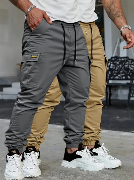 Men’s slim fit cropped gray cargo joggers with black drawstring waist and a small yellow brand patch on the thigh.