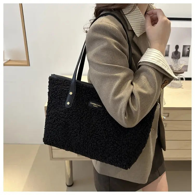 Black textured tote bag with sleek leather straps and a subtle brand plaque paired with brown faux fur tote bag featuring leather straps.