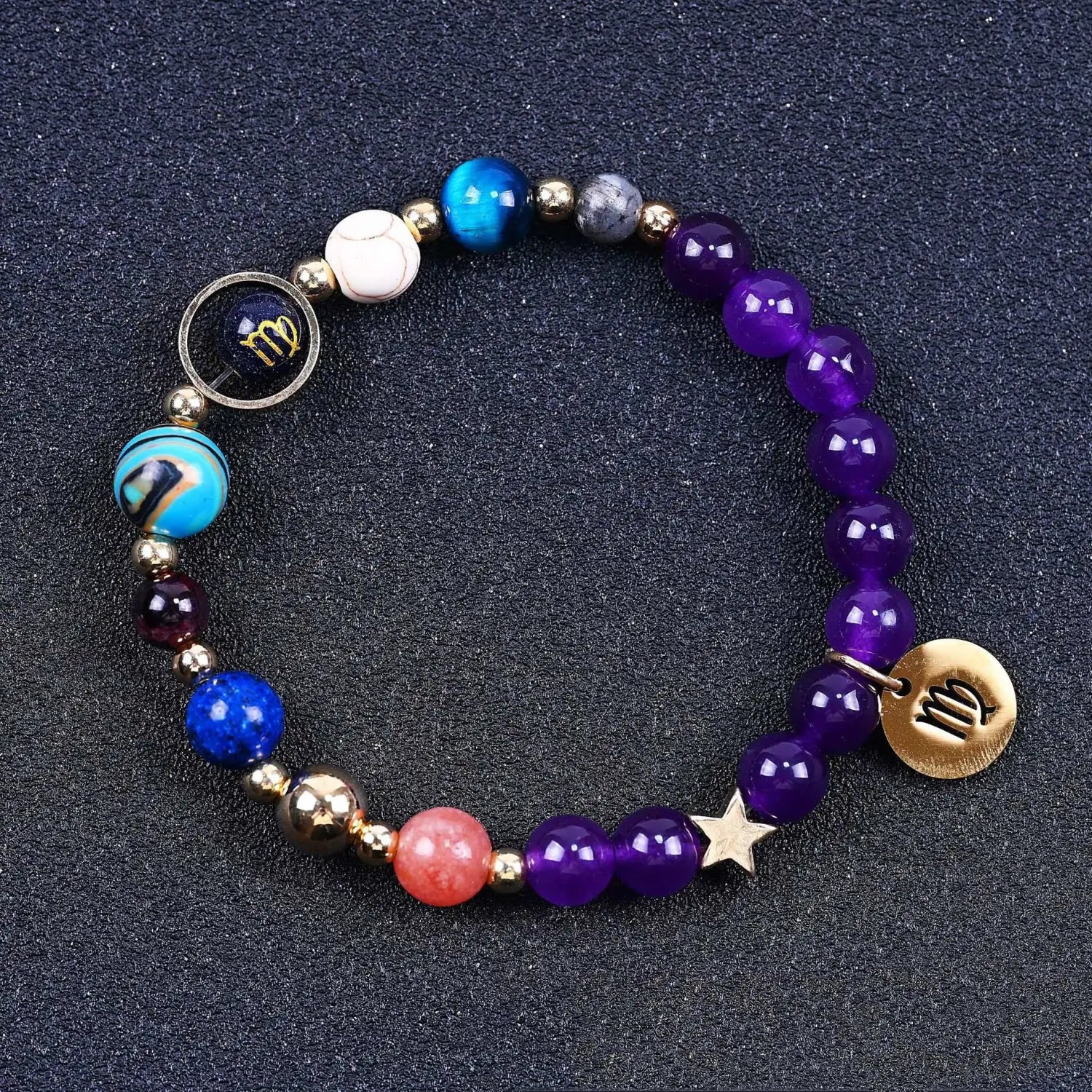 A vibrant stretchy bracelet featuring natural amethyst and agate purple blue and pink gemstones with gold-toned metal accents and zodiac-themed charms.