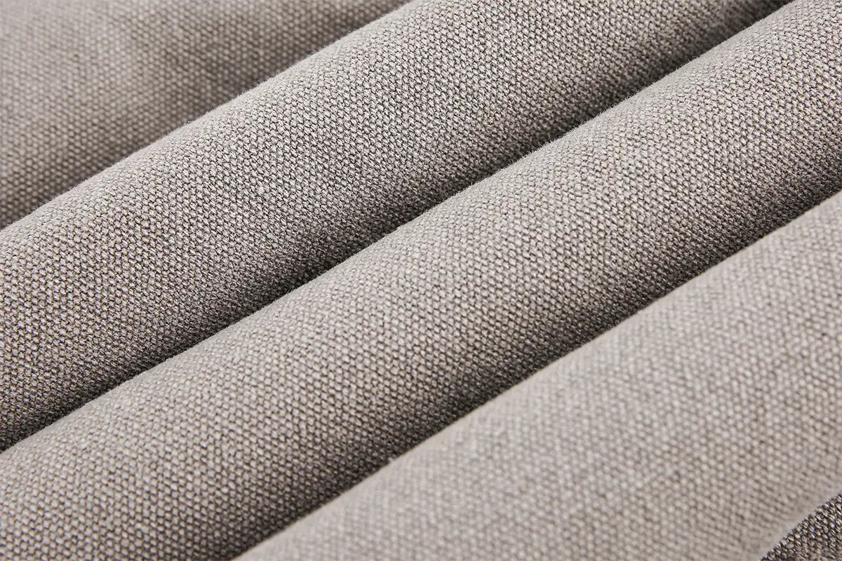 Tejido texturizado gris de un abrigo acolchado de invierno de algodón con forro de piel sintética para hombre y mujer, con un tejido ligeramente tosco entrelazado.