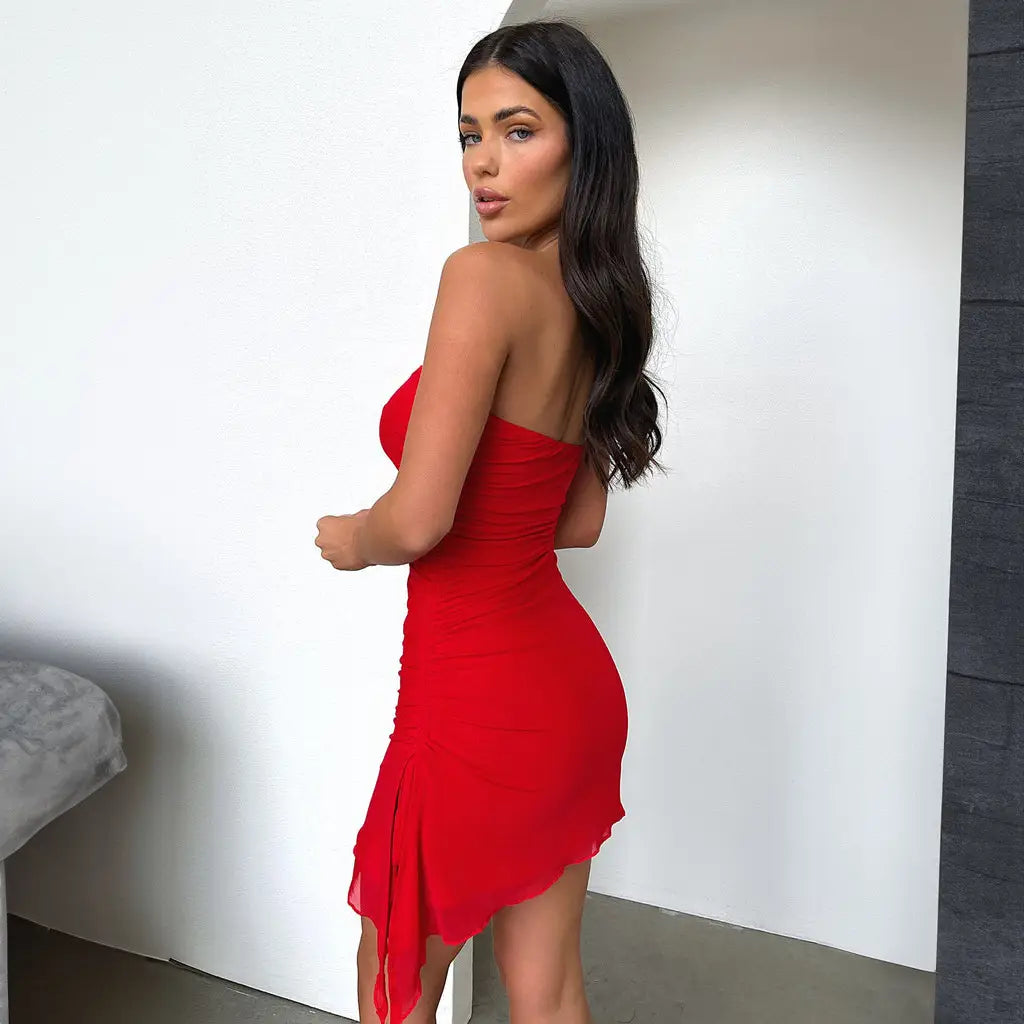 A vibrant red Y2k ruched strapless mini dress featuring a fitted silhouette and asymmetrical hemline.