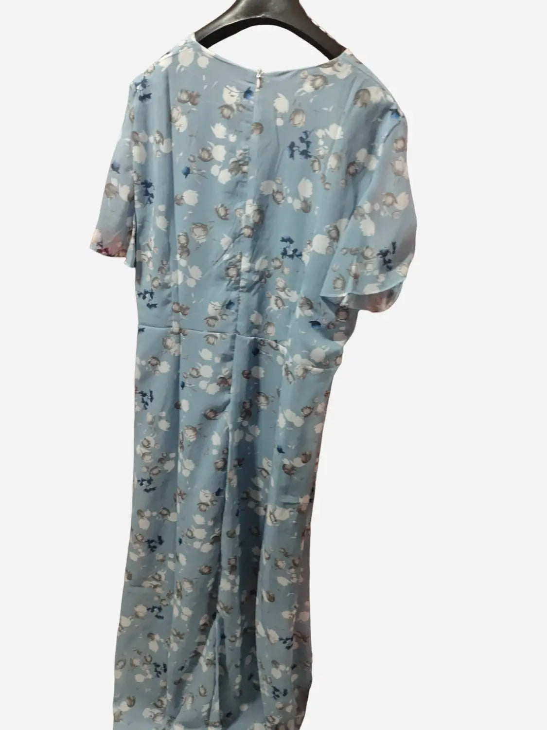 Une robe bleu clair à manches courtes à imprimé floral, avec un col rond suspendu à un cintre noir, stylée comme une robe longue d’été à volants floraux à décolleté en V.