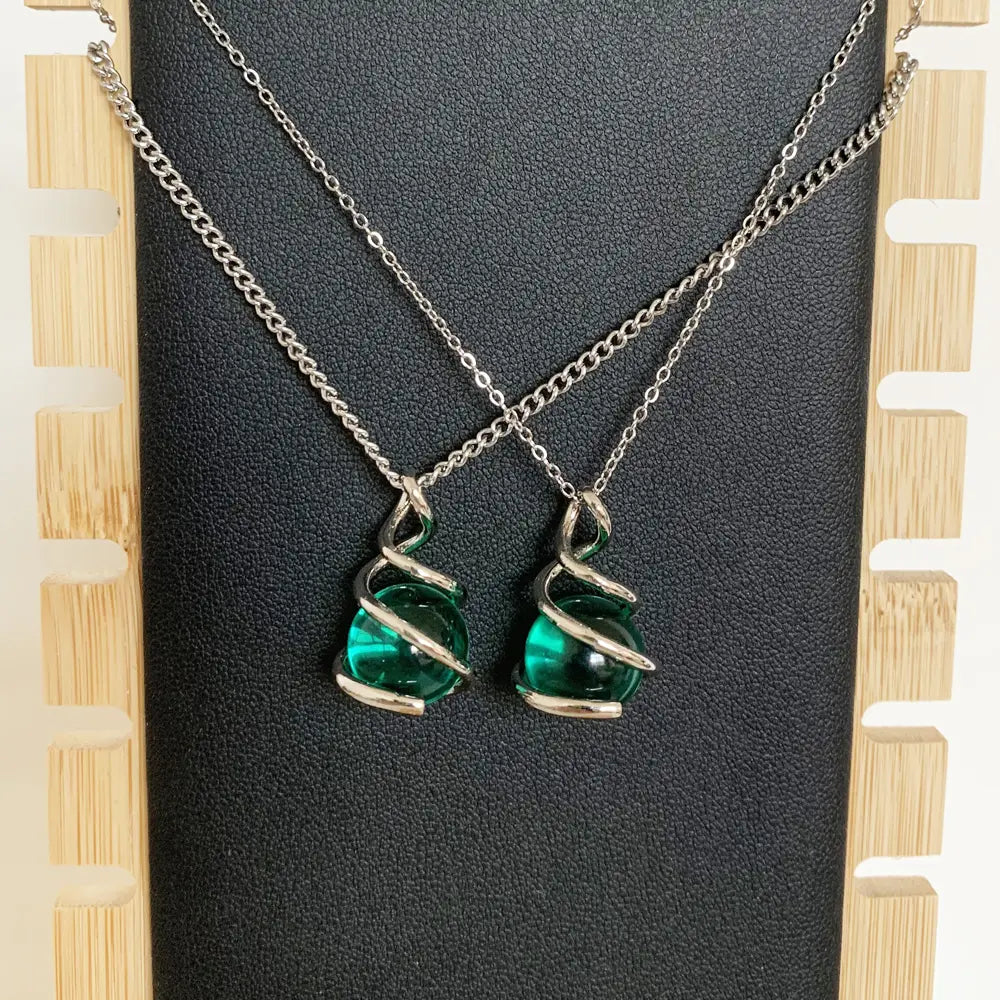 Collares con colgantes de esfera de vidrio color verde esmeralda, con envoltura de alambre retorcido de tono plata para una joyería elegante.