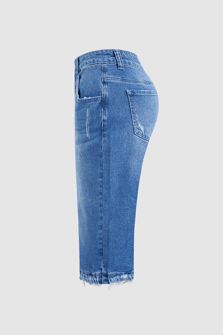 Pantalones capri de mezclilla azul rasgados con detalles desgastados y dobladillo deshilachado, mostrados desde el reverso.