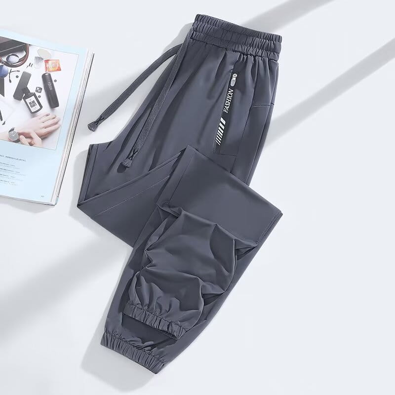 Dark gray anti-mosquito casual athletic trousers with elastic waistband, drawstring, and side pocket featuring fashion branding in white lettering.