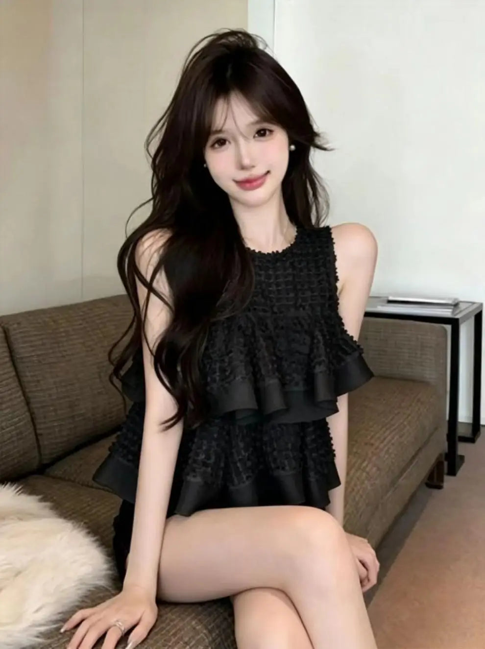 Vestido negro sin mangas con volantes en capas y tejido con textura, diseñado como un top de blusa negra sin mangas con volante fruncido en capas.