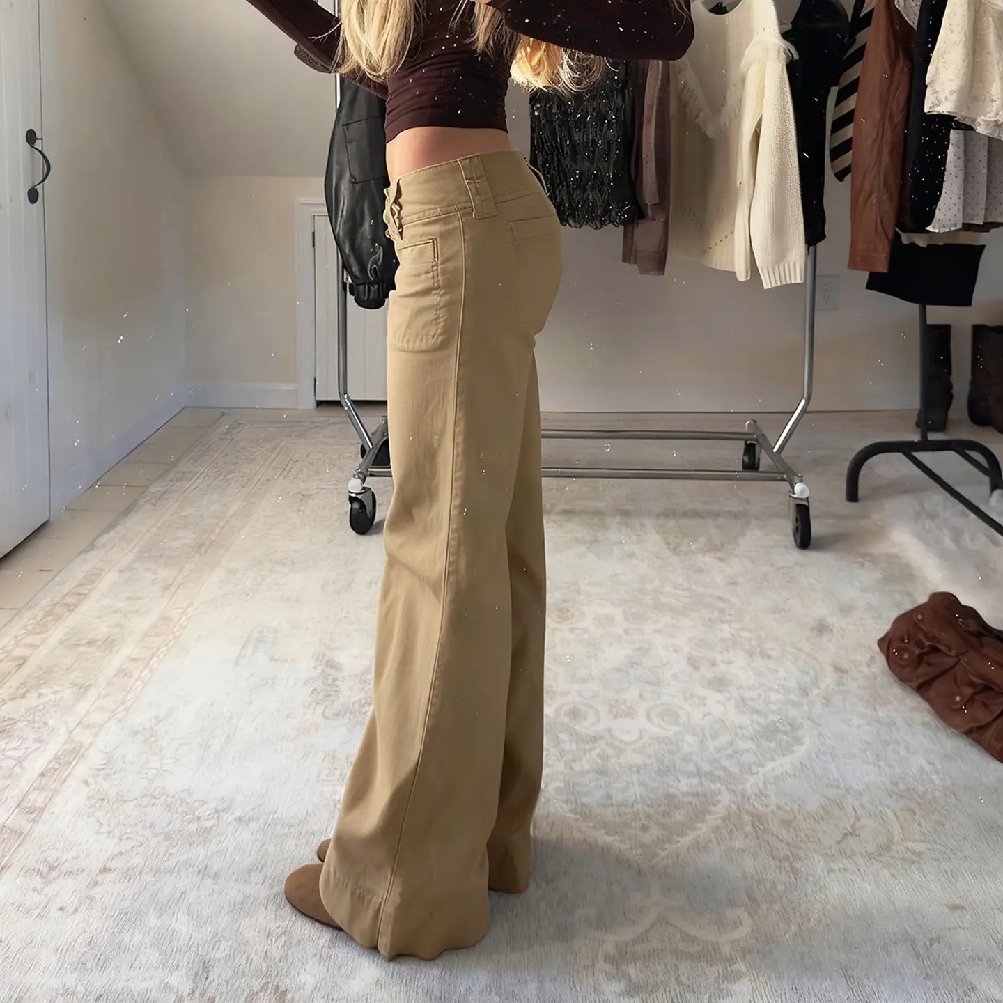Flared tan low rise denim trousers featuring wide-leg design, high waist, and front pockets.