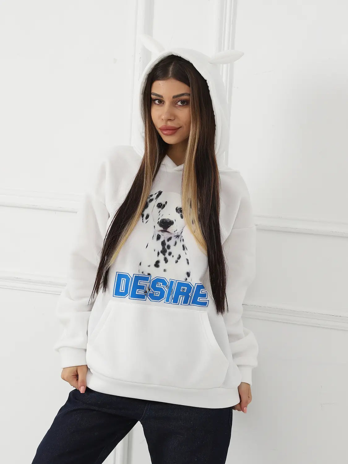 white hoodie featuring a black and white dalmatian graphic and blue desire lettering across the chest with a cat ear hood designed for women