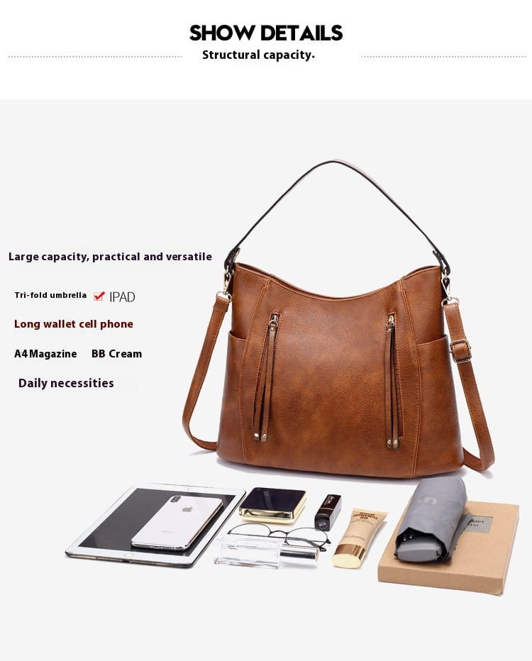 Brown leather hobo bag with tassel, front zipper pockets, structured slouchy design, and dual shoulder straps.