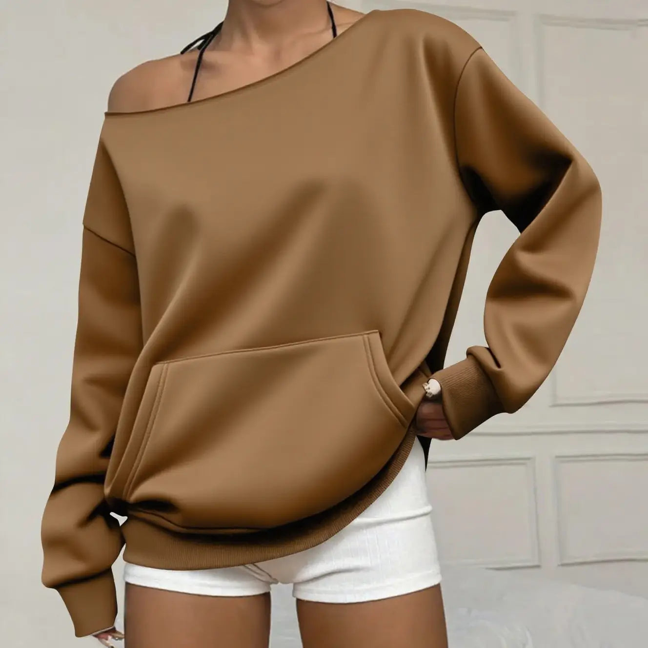 Ein gemütlicher schulterfreier Pullover in Kamel-Farbe aus weichem Material mit Fronttasche und gerippten Bündchen.