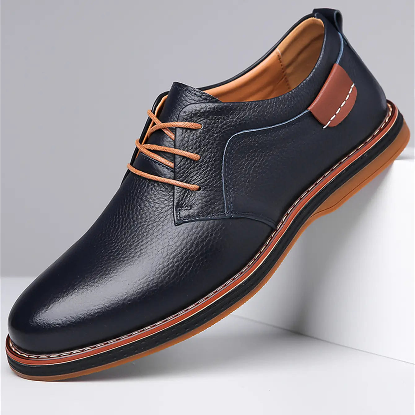 Men’s handmade genuine leather lace up Oxford shoe in dark blue leather with tan laces and a contrasting brown rubber sole.