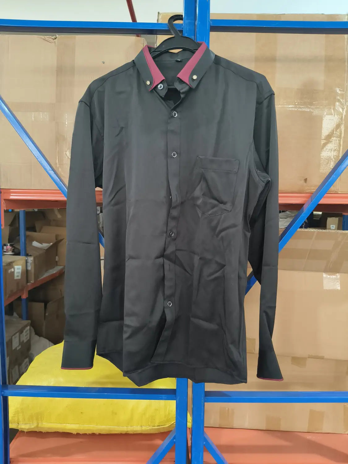 Herren Stretch-Anzughemd mit Kontrastkragen in Schwarz mit bordeauxrotem Kragen und Manschetten, hängend auf einem Bügel.