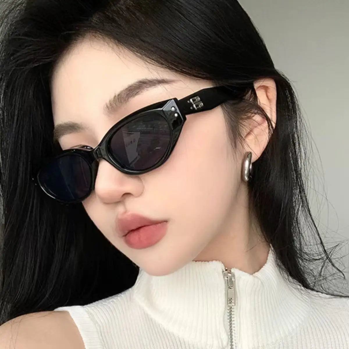 Black cat-eye uv400 sunglasses with glossy modern frames and metallic hardware details.