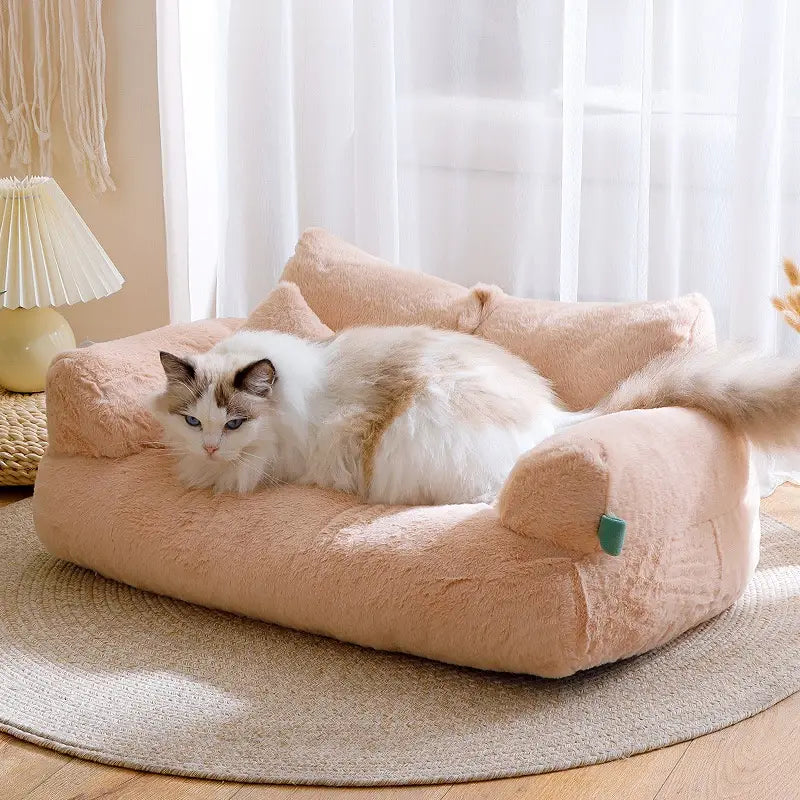Soft peach-colored plush cat sofa bed with cushioned armrests and cozy upholstered design for warm winter pet lounging in beige.