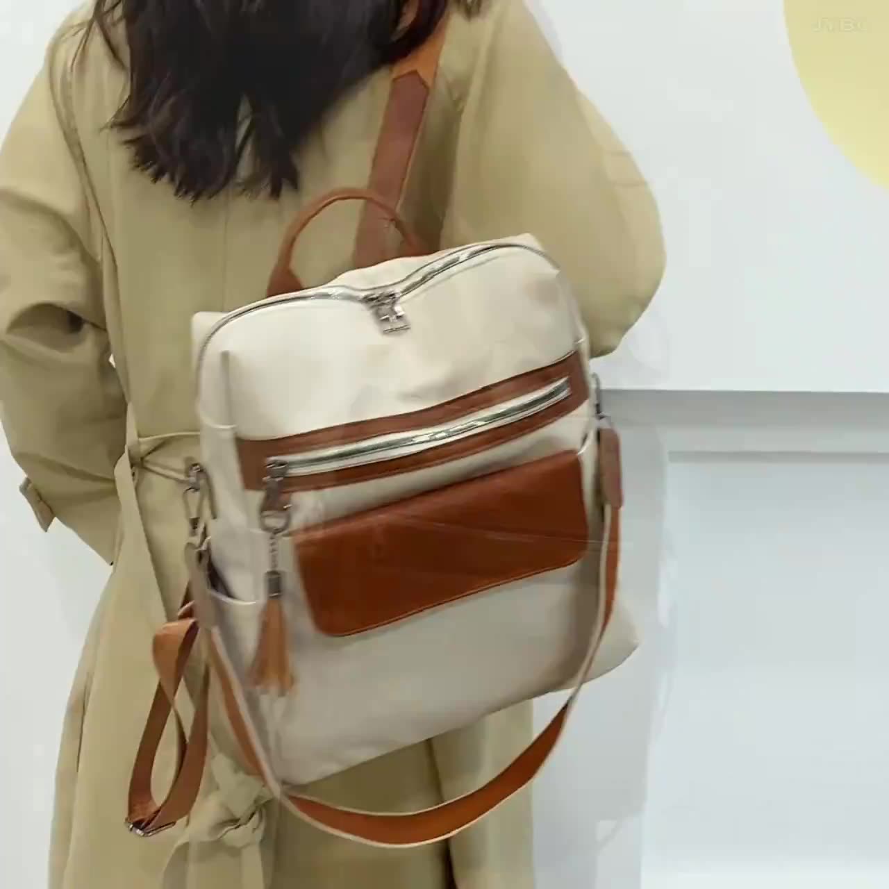 One shoulder cream faux leather backpack 35cm in beige canvas with brown leather accents and zippers.