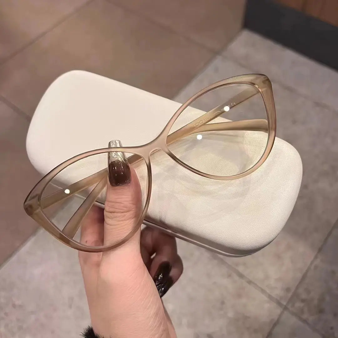 Une paire de lunettes de soleil œil-de-chat beige translucide UV380 légères pour la mode, au design moderne et épuré.