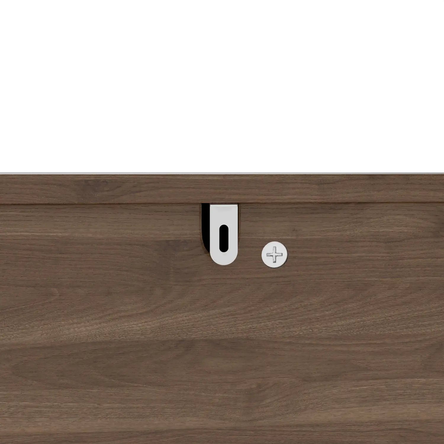 White plastic drawer pull with black rubber grip mounted on a dark wood-grain surface of corner dog crate furniture with fluted storage drawer.