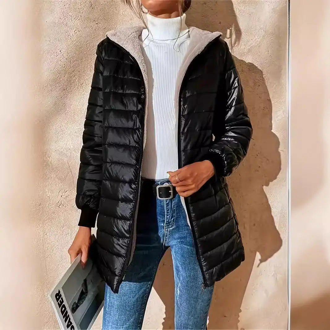 Doudoune matelassée noire pour femme, dotée d’une capuche en polaire grise duveteuse, conçue pour vous tenir chaud et vous assurer un confort optimal.