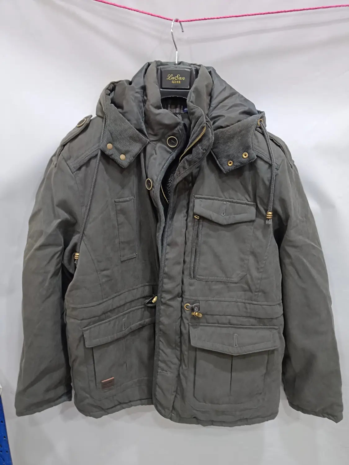Parka de invierno acolchada con forro polar para tallas grandes color gris oscuro, con capucha, múltiples bolsillos frontales y herrajes de tono dorado.