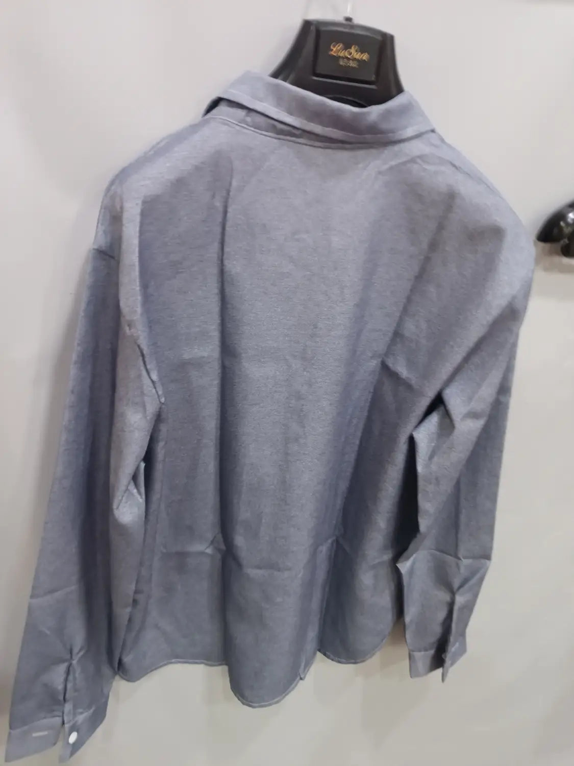 Ein grauer Herren-Cardigan mit kurzer Ärmellänge und strukturierter Optik, mit dezentem gewebtem Muster und ordentlich gefalteten Bündchen.