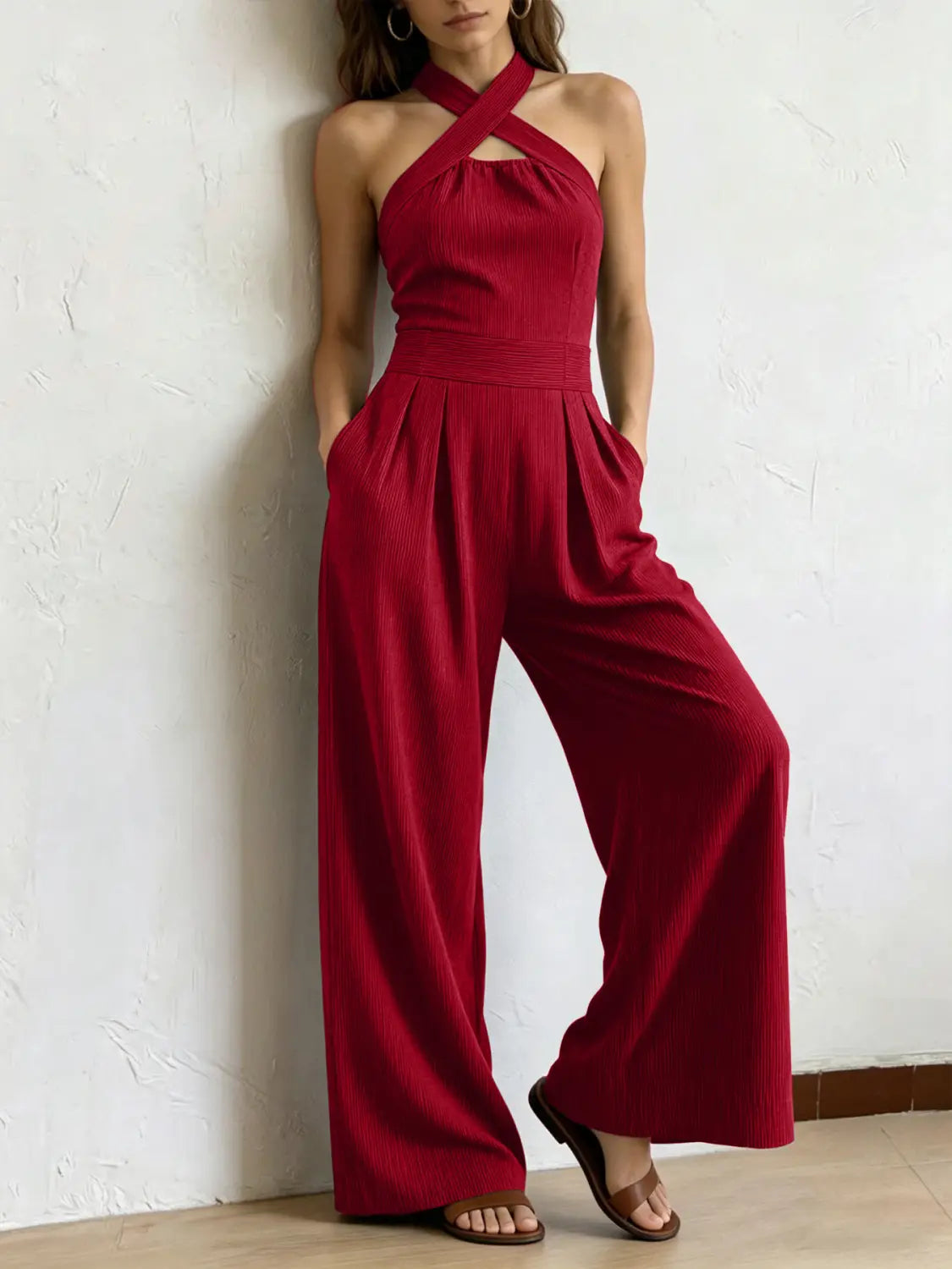 Ein leuchtend roter gerippter Halterneck-Jumpsuit mit gekreuztem Frontausschnitt und Hosen im weitem Bein