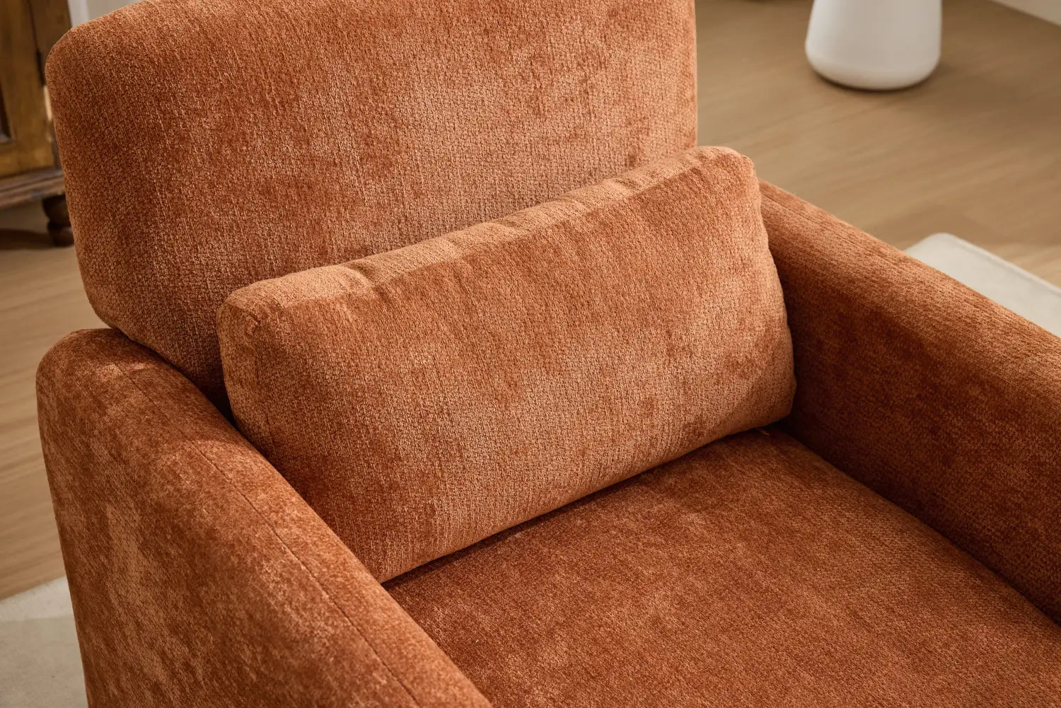 Ein moderner Bouclé-Akzent-Sessel, gepolstert mit rustfarbenem, strukturiertem Stoff, mit plüschigen Kissen.