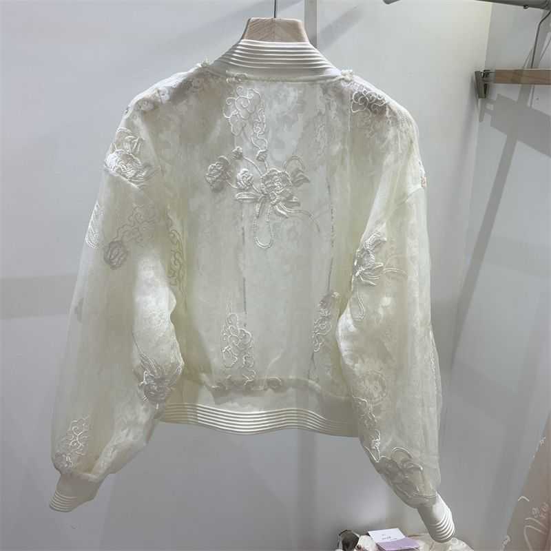 精緻なシルバーフローラル刺繍とリブ仕立てのカフスを備えたアイボリーのレースボンバージャケット。