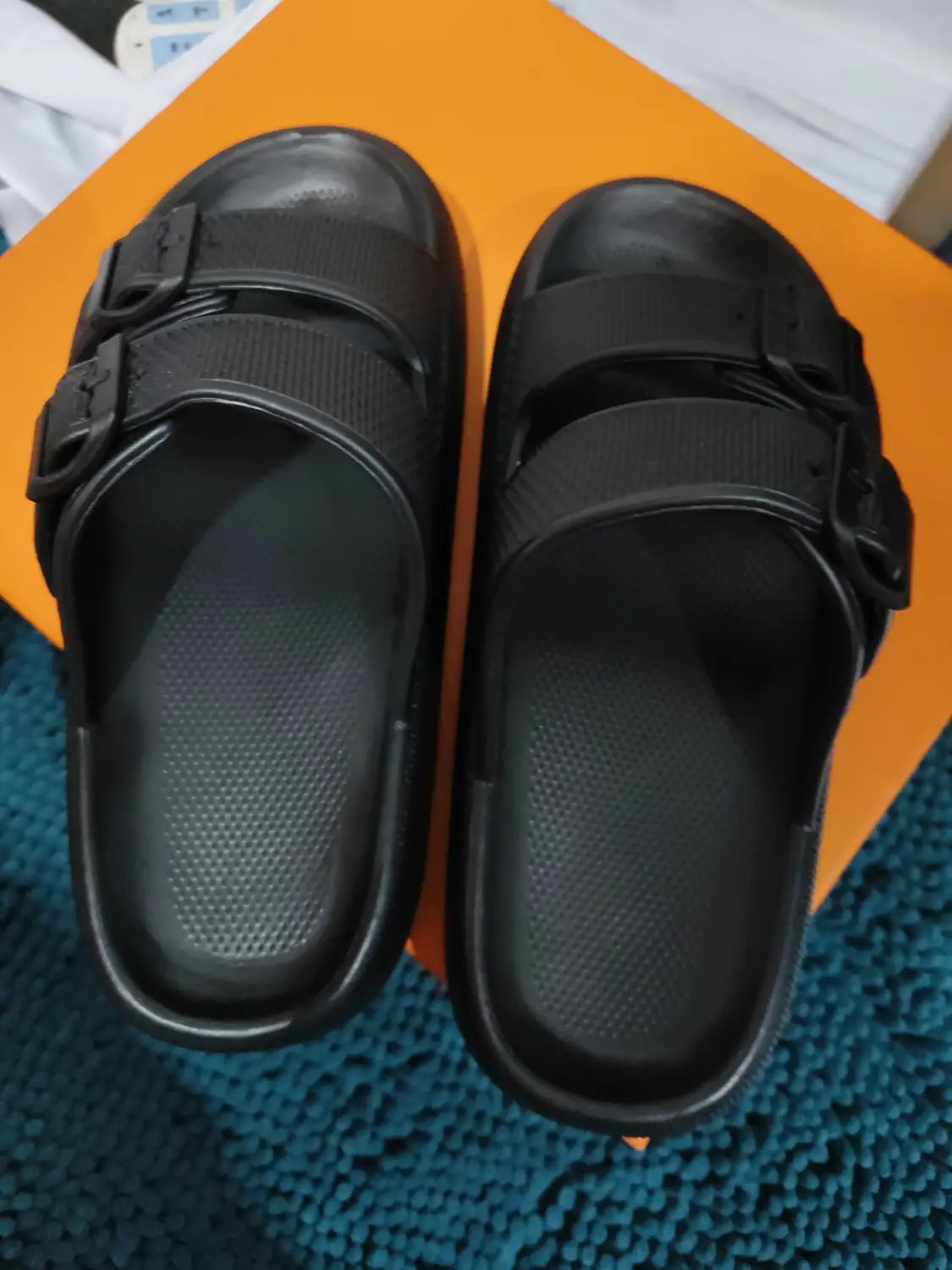 Las sandalias tipo plataforma Eva con hebilla de color negro incluyen dos correas ajustables y una suela gruesa transpirables, con plantilla texturizada para facilitar el deslizamiento cómodo.