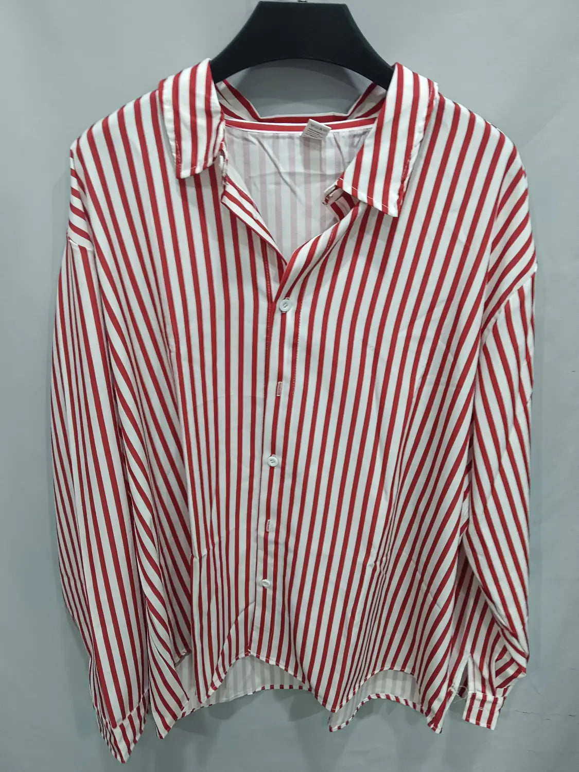 Chemise décontractée à manches longues rayée verticalement rouge et blanc pour hommes, avec coupe légèrement ample et design boutonné.