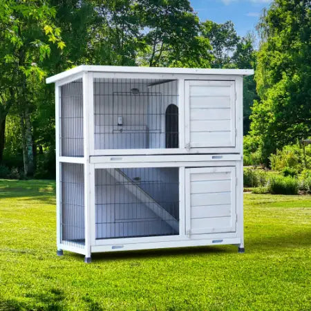 Cage en bois pour lapins à deux niveaux, blanche, avec côtés en treillis métallique et bacs, conçue comme une cage à 2 étages avec parc.