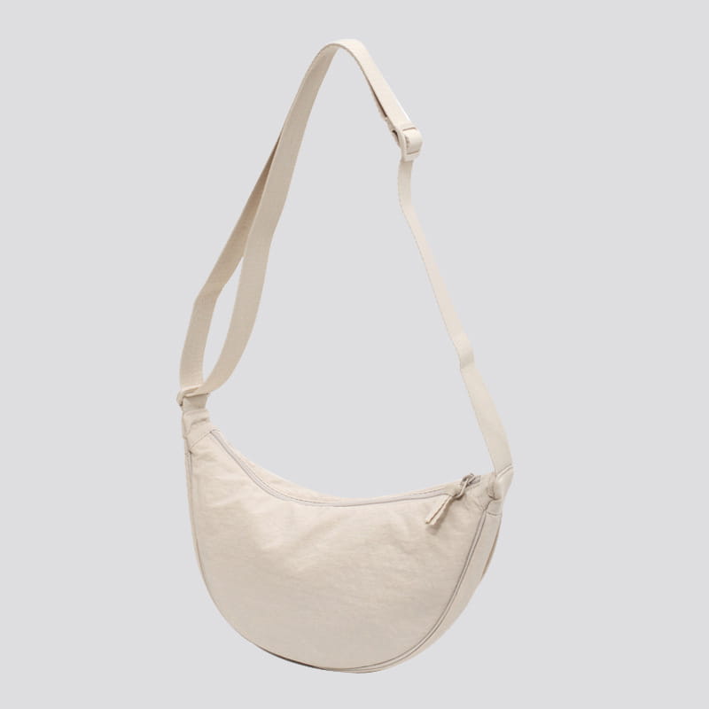 Cream-colored nylon dumpling messenger bag with a sleek curved design and adjustable crossbody strap made of canvas.