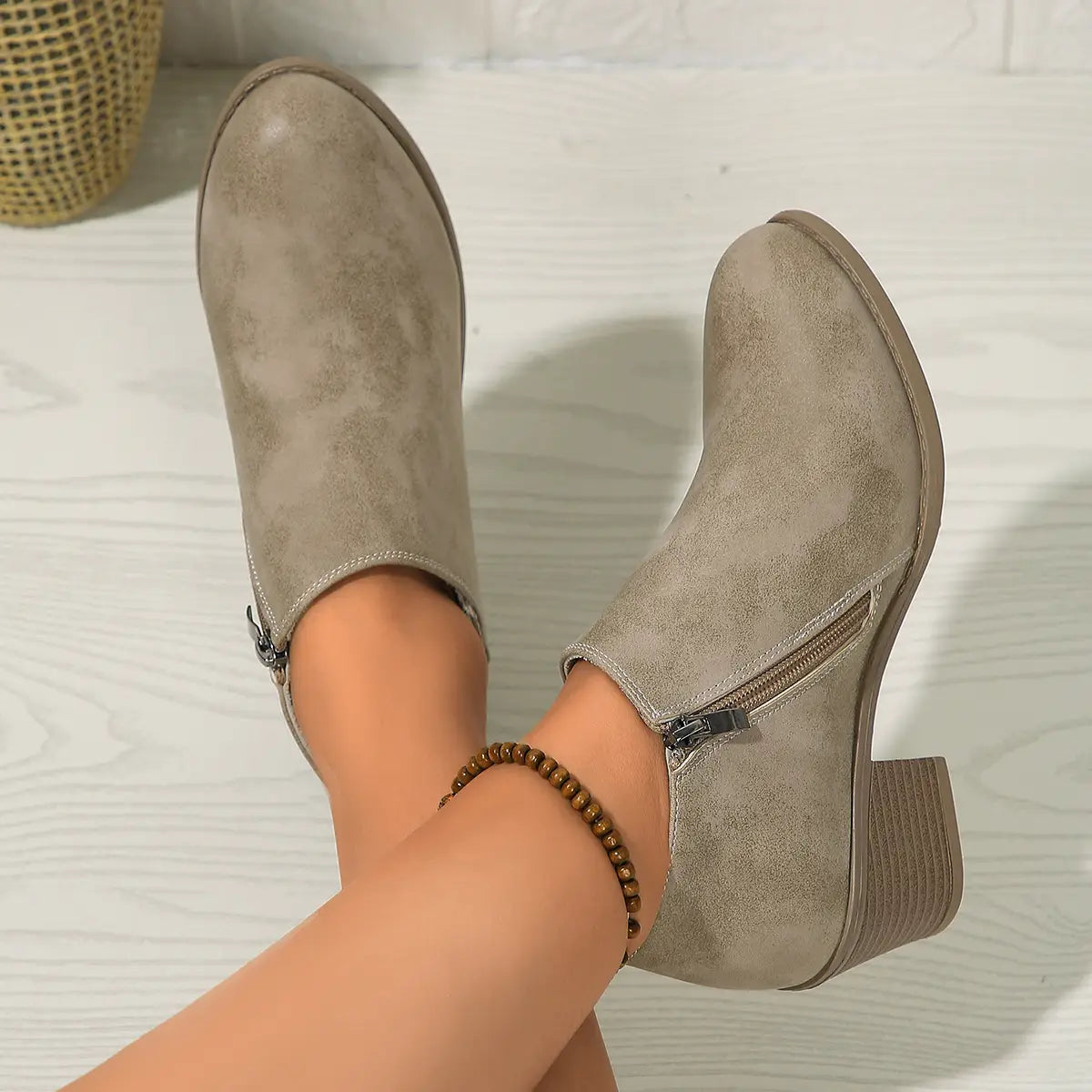 Sleek taupe suede ankle boots with a low chunky heel and side zipper closure.